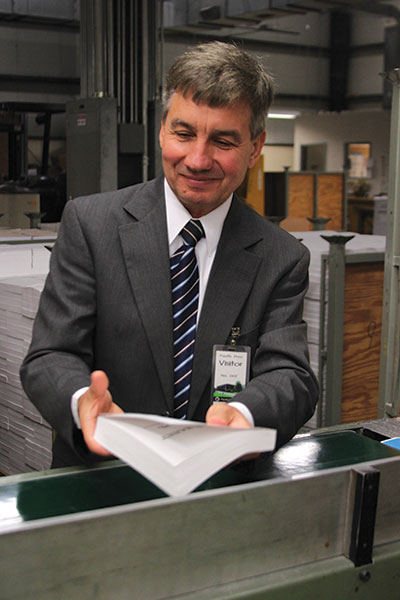 <strong>EMOTIONAL MOMENT:</strong> Mikhail Kulakov, Jr., holds a Russian Bible—New Testament and Psalms—one of the first to roll off the press. 