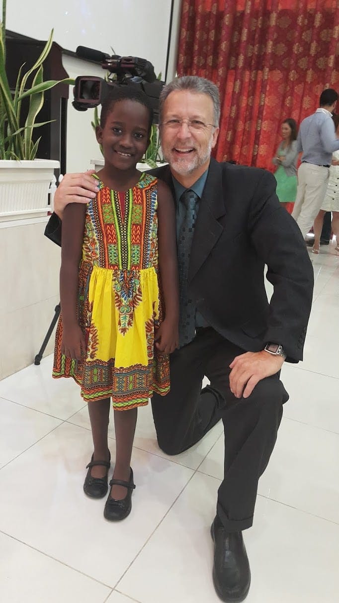 Pastor Lee Venden posing with a girl at the camp meeting.