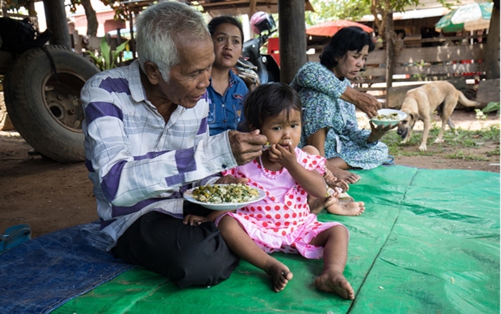 Thanks to ADRA, Grandfather has learned how to prepare nutritious meals for his two young grandchildren. A widower, he is their only provider. [Photo: ADRA Canada]