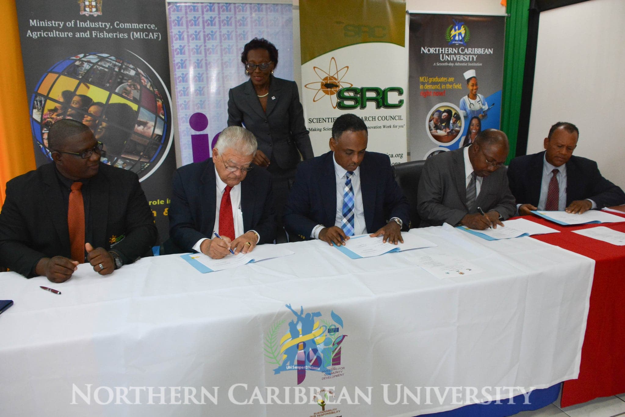 From left to right: Scientific Research Council Executive Director, Dr. Cliff Riley, Minister of Industry, Commerce, Agriculture and Fisheries, Karl Samuda, Jamaica Social Investment Fund Project Officer Dawn Allison (standing) Jamaica Social Investment Fund Managing Director, Omar Sweeney, Northern Caribbean University Provost Dr. Paul Gyles, and Dean of the College of Natural and Applied Sciences at NCU, Dr Vincent Wright signing the in-vitro propagation of Irish potato seed program in Kingston, Jamaica. Image courtesy of NCU