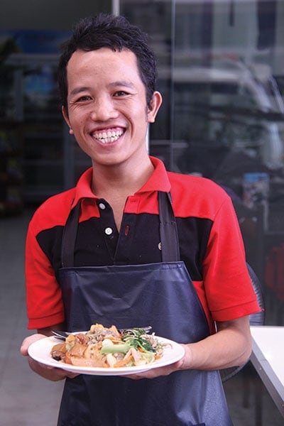A Friendly Smile: A staff member at Manna vegetarian restaurant in Laos welcomes customers. Teresa Costello/SSD