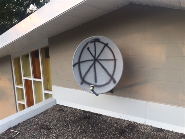 Unknown people spray-painted the flat roof sections of Guelph Seventh-day Adventist Church in Guelph, Ontario, Canada, with hate messages. They also sprayed the church satellite dish. [Photo: Ontario Conference News]