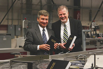 Mikhail M. Kulakov (left) and Dale Galusha, hold new translations of the Bible in Russian, printed at Pacific Press.