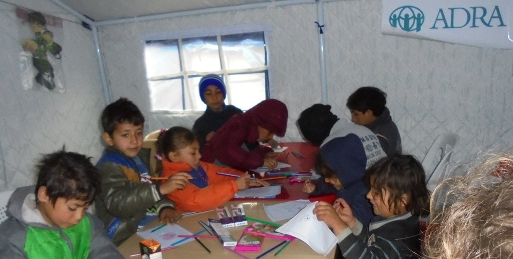 Children drawing pictures and conversing as part of in ADRA’s informal education program at the Baharka camp. (ADRA)