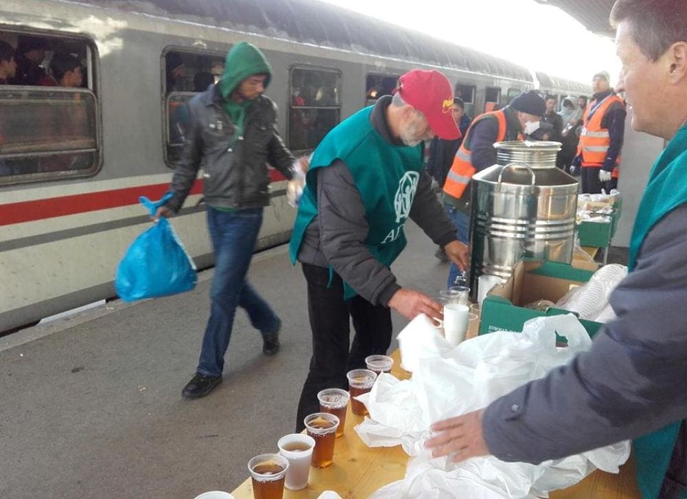 ADRA volunteers offering hot tea to refugees at the train station in Dobova, Slovenia. (ADRA Hungary)