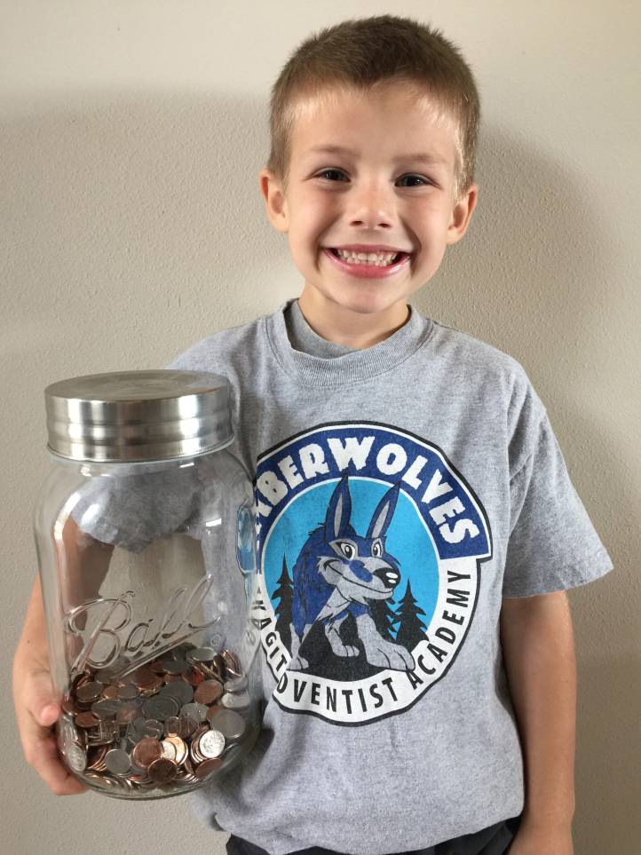 Brady with his piggy-bank jar as its collection of coins started growing.