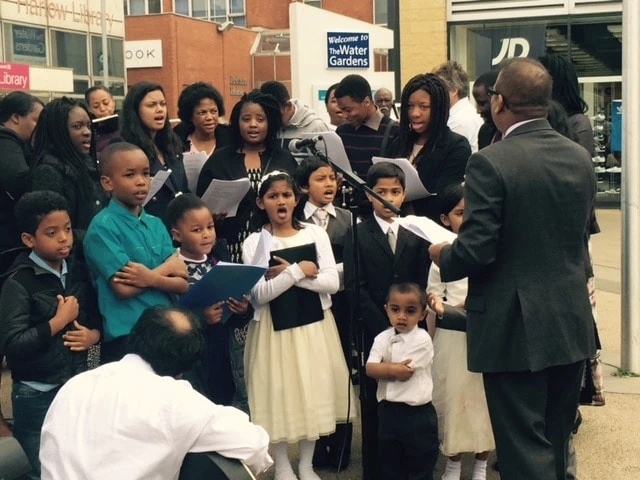 Church members sing in Harlow town square during Sabbath morning services. (BUC)