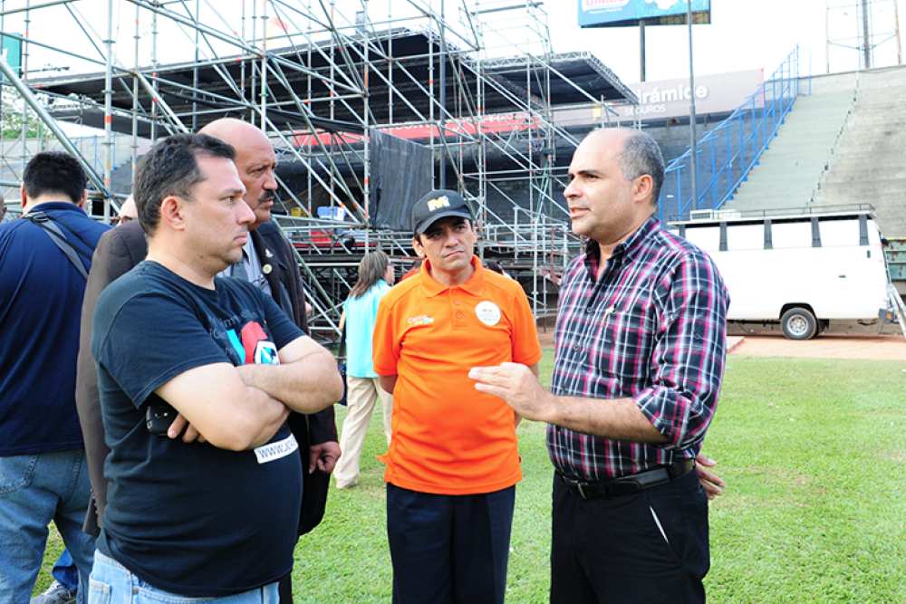 Josney Rodriguez, right, president of the Adventist Church in east Venezuela, talking with event coordinators at the Caracas University Stadium on April 14, 2016. (Libna Stevens / IAD)