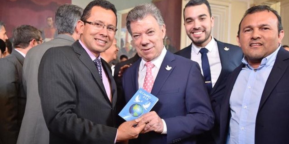 Alvaro Niño, left, handing a copy of "The Road to Peace” to President Juan Manuel Santos on July 4, 2016. (IAD)