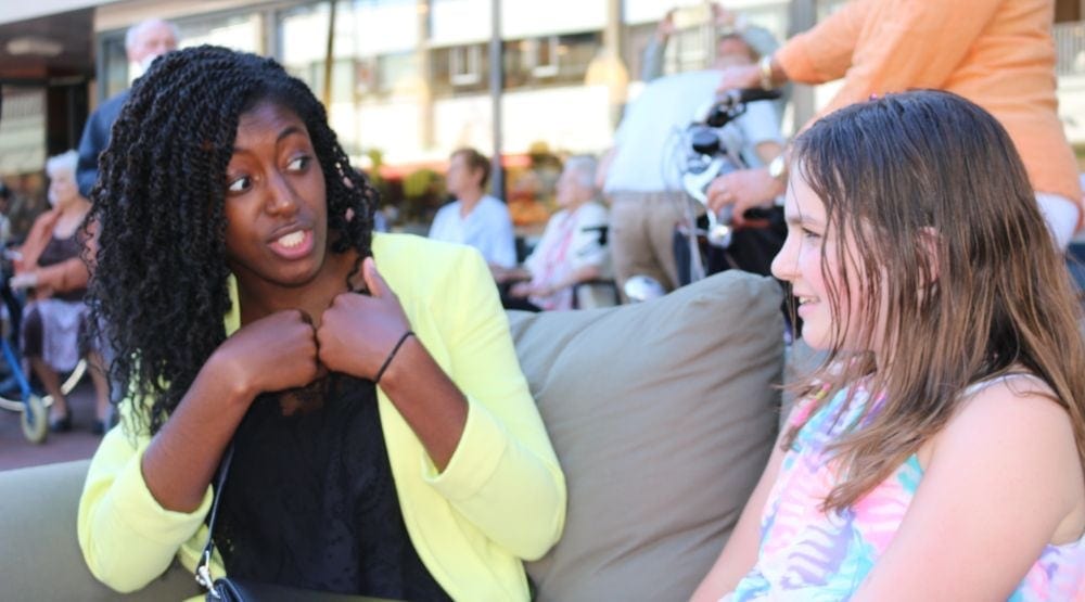 Jenny Simpeh, 21, from Rotterdam, speaking with a girl on the Sabbath sofa. (Chigemezi N. Wogu)
