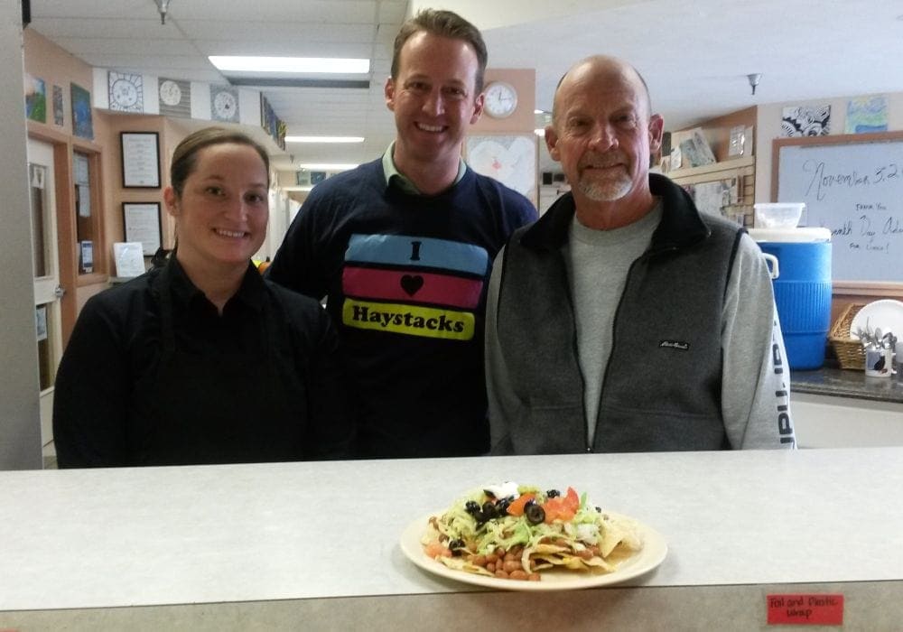Tiffany Neil, Darin Patzer, and Doug McCoy posing with a plate of haystacks at Crosswalk. (GleanerNow)