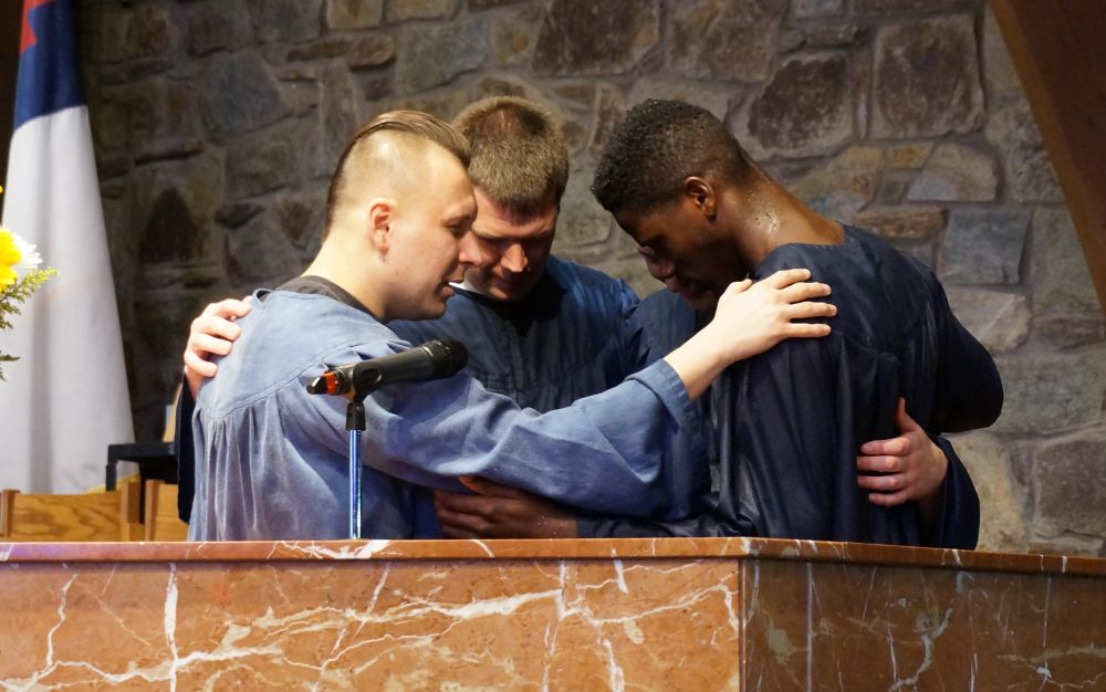 Jacob Harris praying with Justin Montero and Spencerville church youth pastor Stephen Finney at his baptism. (Juliana Baionin / Visitor)