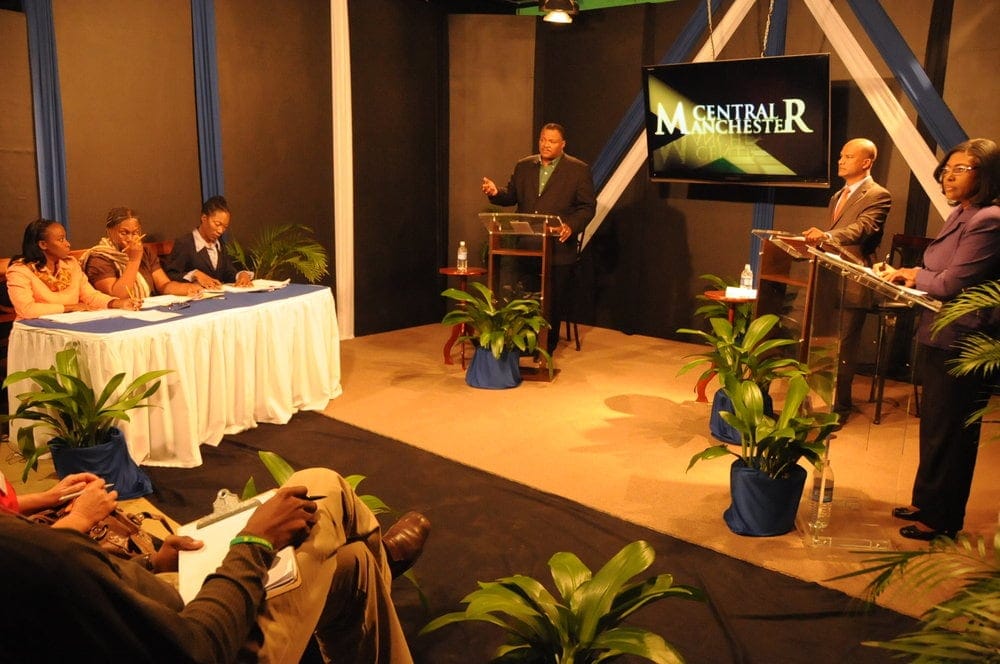 A constituency debate between National Security Minister Peter Bunting, right, and his then-opposing candidate in the constituency, Danville Walker, at Adventist-owned Northern Caribbean University in Manchester, Jamaica, in December 2011. Campaign rhetoric from opposing candidates has grown heated in recent years. (Nigel Coke / IAD)