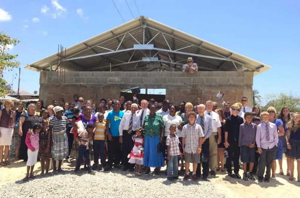 Volunteers and church members standing outside the partially built Brisas del Edén Church.
