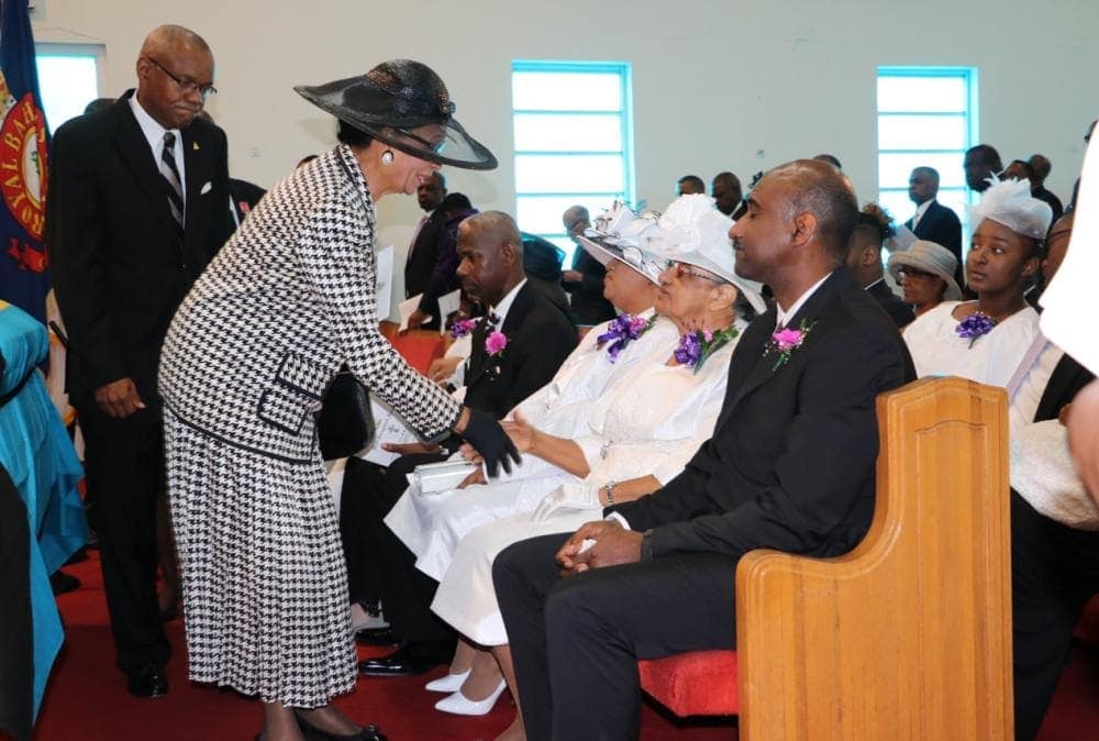 Governor General Marguerite Pindling greeting Ruth McKinney at the funeral while Atlantic Caribbean Union president Leonard Johnson follows behind.