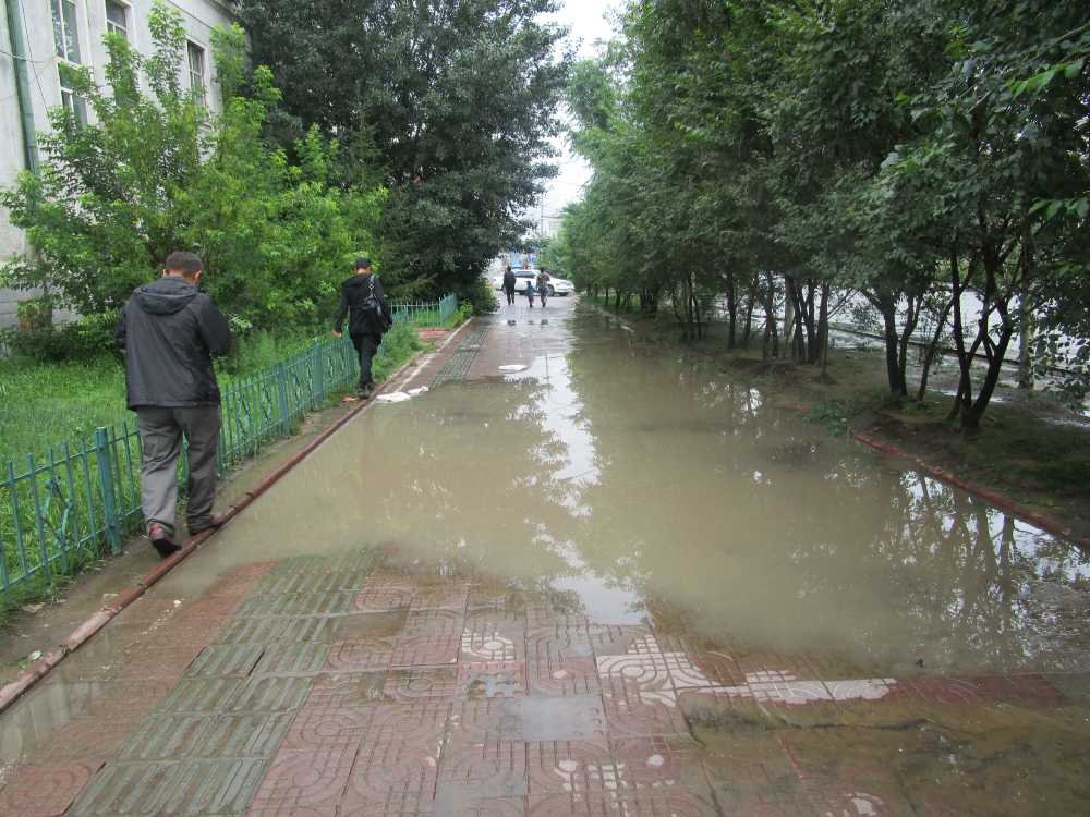 People avoiding water puddles after a downpour in Ulaanbataar.