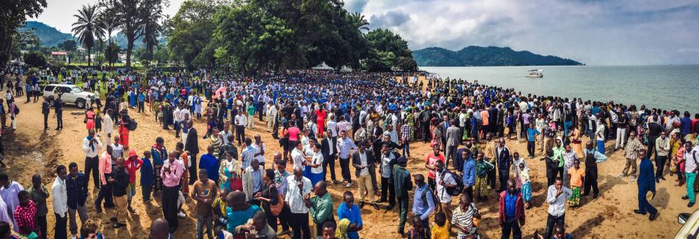 Hundreds of people awaiting baptism in blue and white robes at Lake Kivu in Rwanda.
