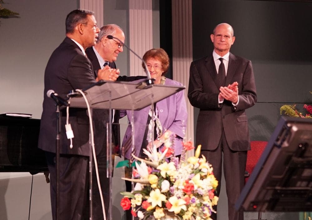 Juan R. Prestol-Puesán, left, paying tribute to longtime General Conference comptroller Verland Erntson, who died in February at the age of 71. Also on the stage Tuesday are Erntson's widow, Jan, retired General Conference treasure Robert Lemon, and General Conference president Ted N.C. Wilson. (Kristina Penny / AR)
