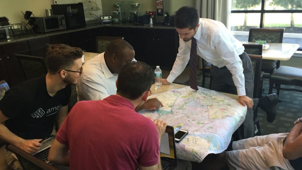 GLOW volunteers planning their distribution routes with the aid of a map.