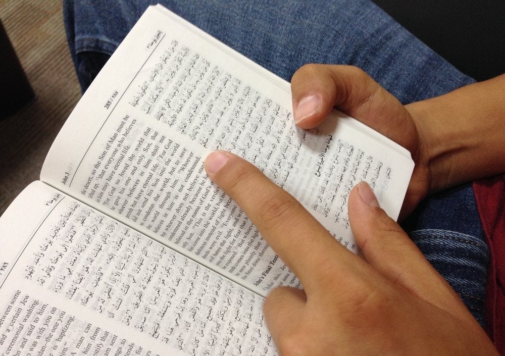 Front-line worker Pedro holding a copy of the Bible in Arabic and English. (Andrew McChesney / AR)