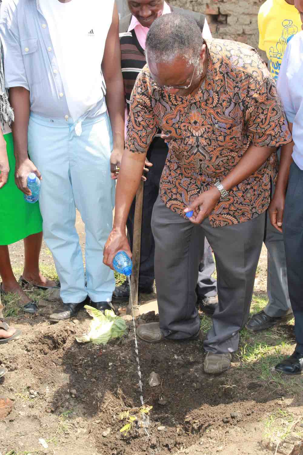 Hudson Kibuuka, associate education director for the Adventist world church, planting a tree on a street named after the Adventist students.