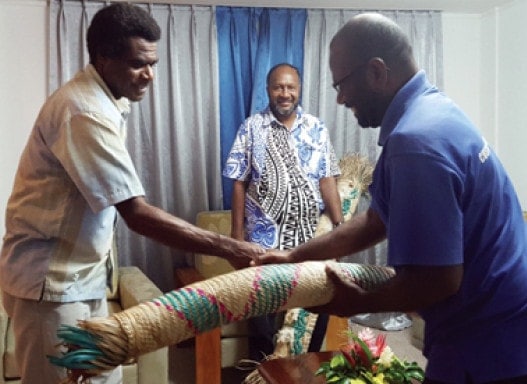 Patrick Fred, left, giving a mat to Prime Minister Charlot Salwai. (Adventist Record)
