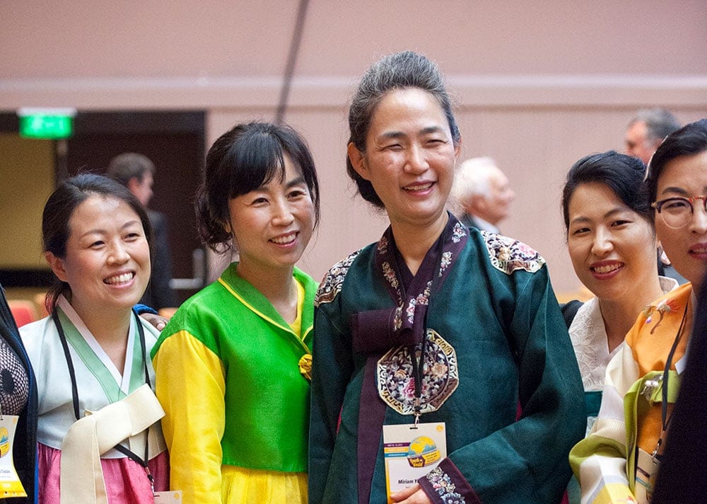 Asian delegates pose for a picture in native outfits. [Photo: Tibor Farago]
