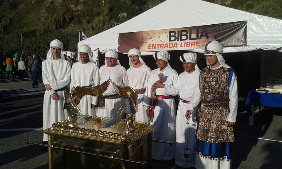 A group of church volunteers dressed as priests of the Tabernacle in the desert welcome visitors to the Bible Expo traveling exhibition in the city of San Sebastian, in northern Spain. Before them is a real size replica of the Ark of the Covenant. [Photo by Spanish Union Conference]