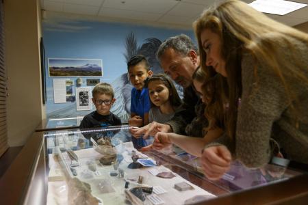 Stan Hudson shows a group of children some of the artifacts on display at the new creation study center. [PHOTO: NPUC Gleaner]