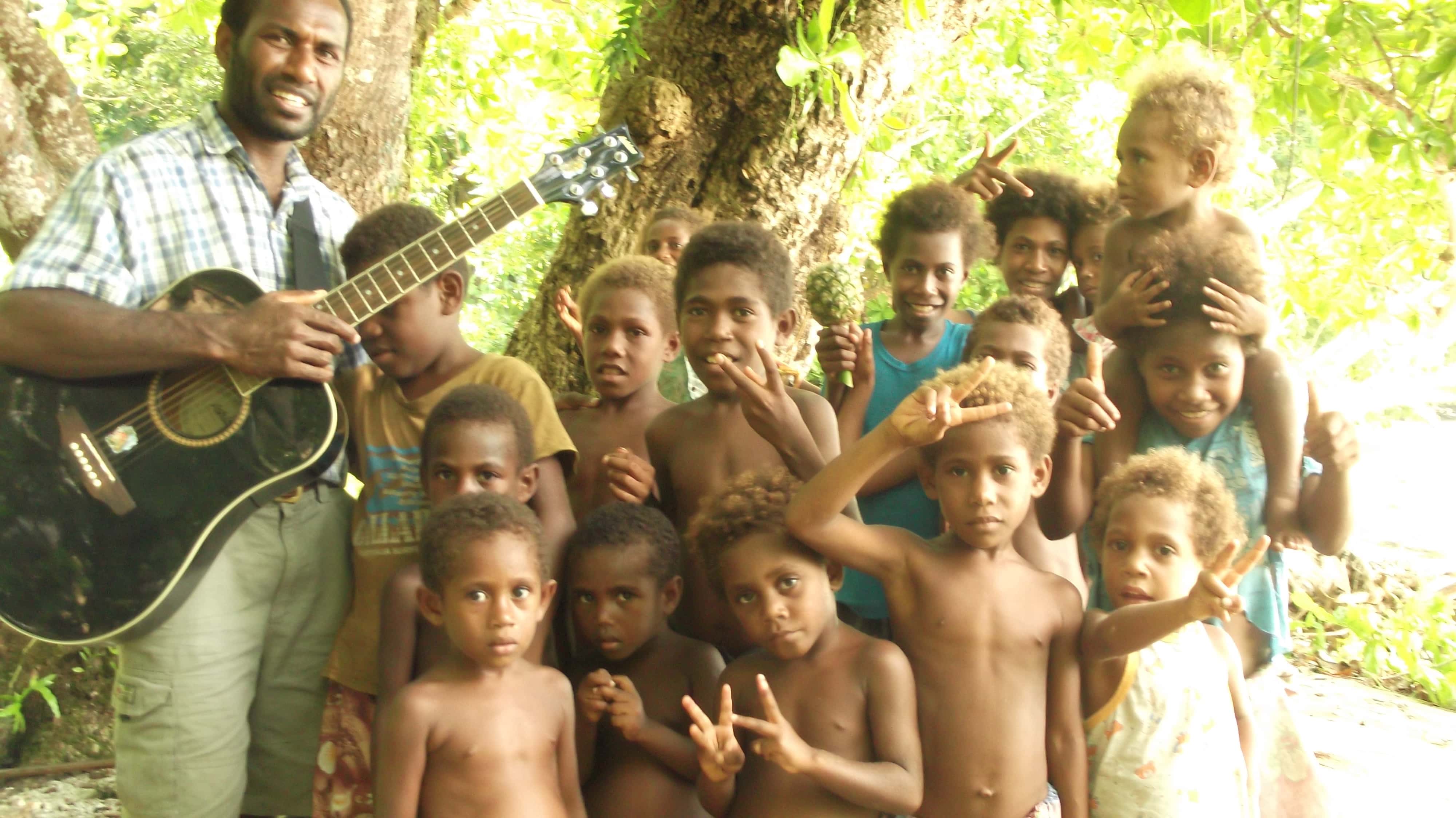 John Joseph, whose Helping Hands ministry works on the Torres islands, sings with village children. Photo: Adventist Record