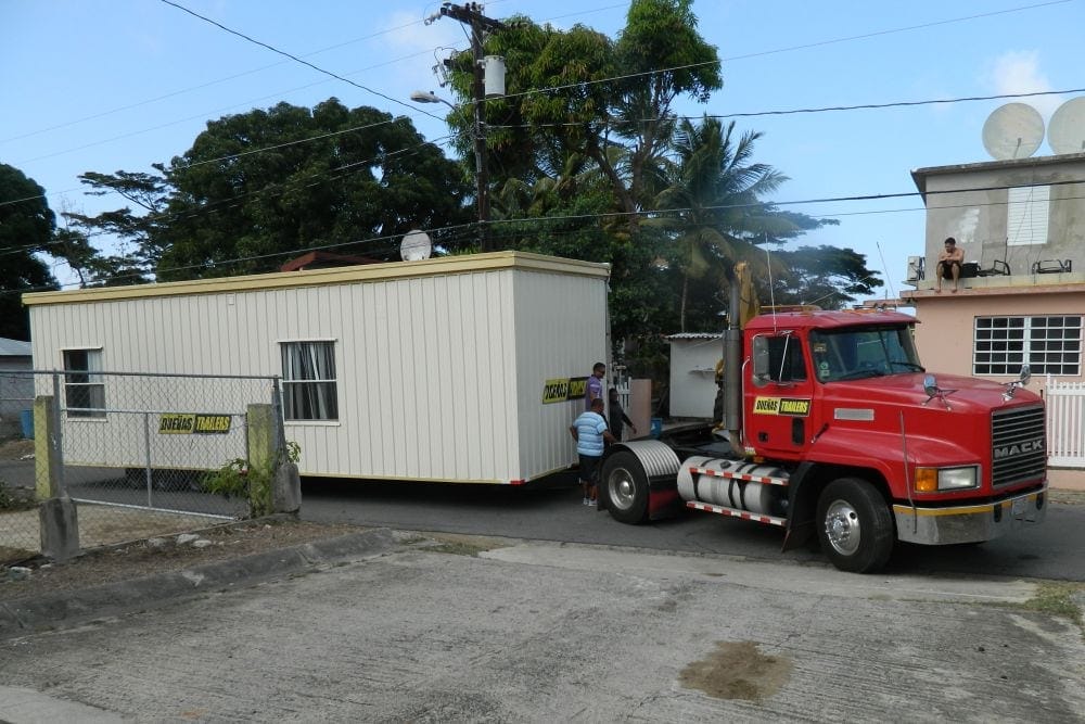 A truck delivering one of the shipping containers that was turned into a classroom last year. (David Sebastian / IAD)