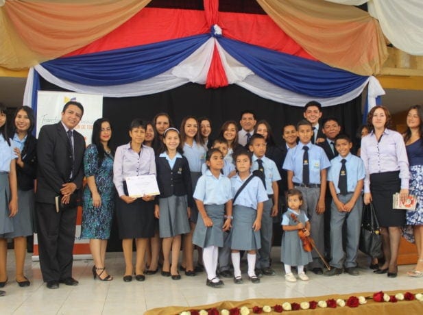 School administrators and student representatives of Colegio Adventista del Ecuador celebrate the "Excellence in Education" 2017 honor the national government awarded to the school. [Photo by South American News Agency]