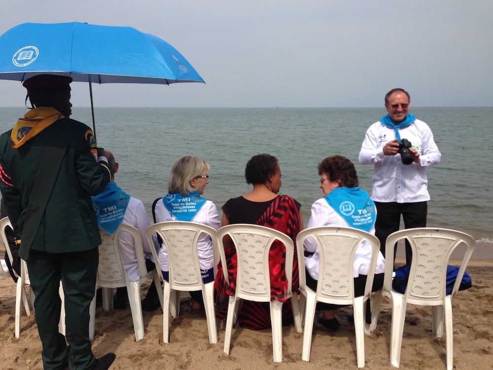 Duane McKey, standing right, taking photos of a mass baptismal ceremony at Rwanda's Lake Kivu in May 2016. (Andrew McChesney/Adventist Mission)