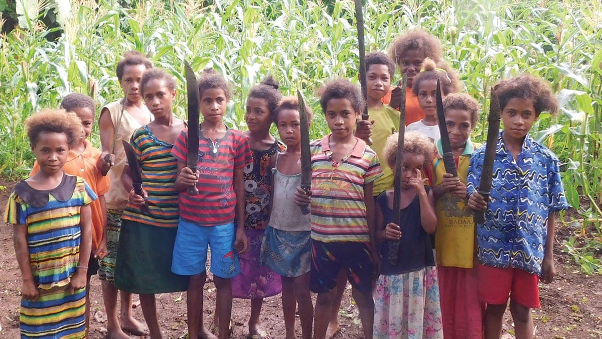 Girls from Kiru village show their gardening machetes and the corn they’re growing to give to the needy. [Photo: Adventist Record News]
