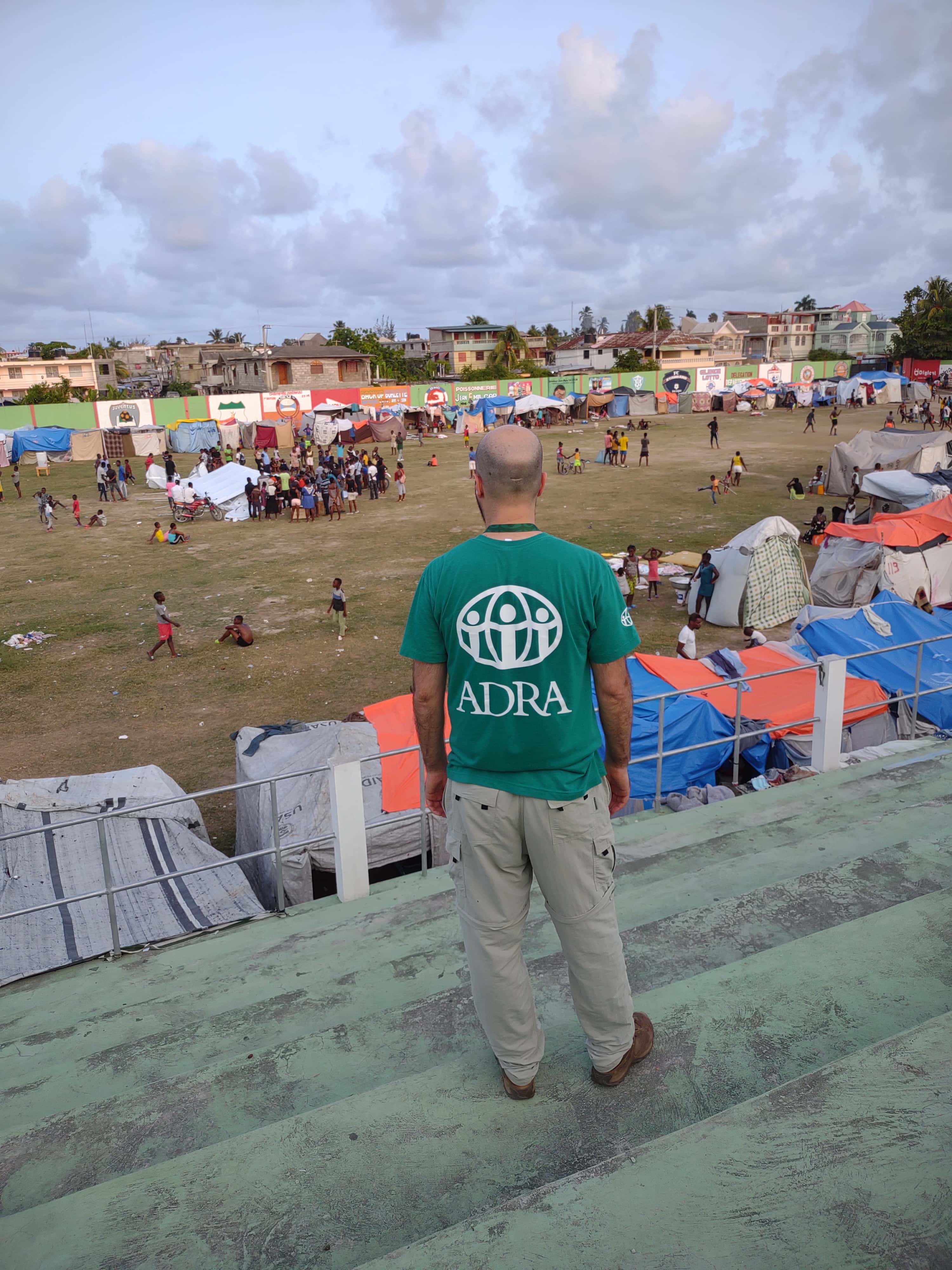 An Haiti ADRA worker looks at one of the camps for the displaced in Haiti after the August 14, 2021 earthquake. [Photo: Lisa Schnurr]