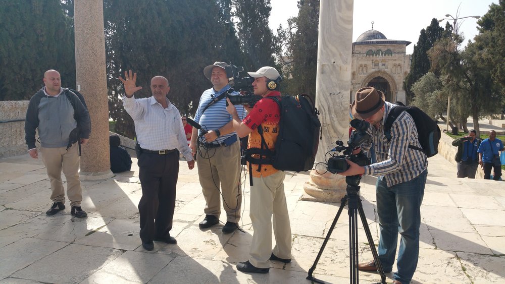 The Russian crew gathering near the Dome of the Rock with the  Al-Aqsa Mosque in the background. The two Waqf guides are standing to the left.