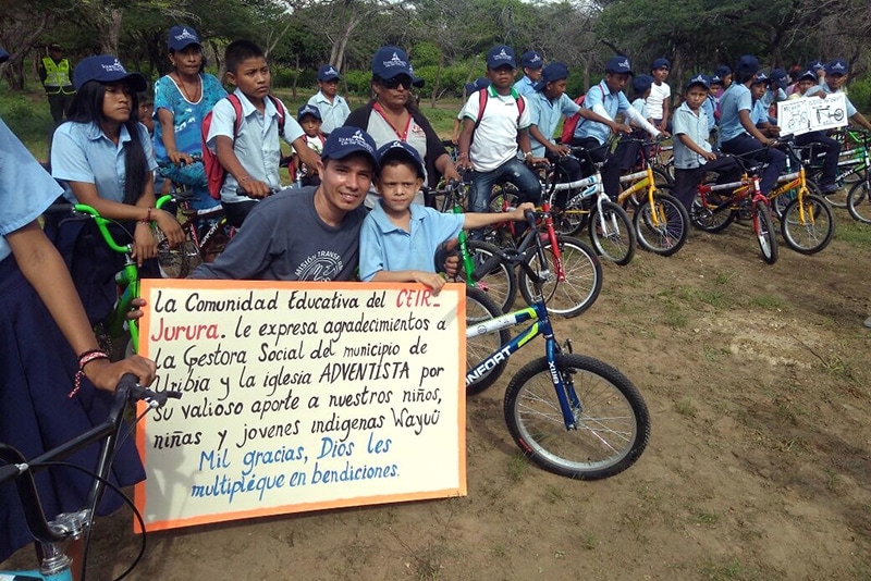 Dozens of children from Uribia in La Guajira, North Colombia, show off their new bikes before they take off, thanks to the “Wheels to Educate” initiative organized by the Adventist Church. Images courtesy of Mauricio Buitrago/NOCU