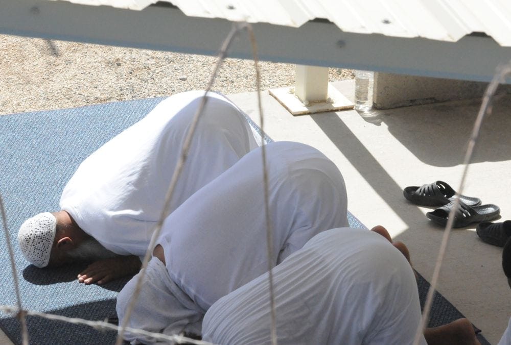 Detainees praying in a recreation area at Guantánamo Bay in 2010. (Gino Reyes / U.S. Air Force)