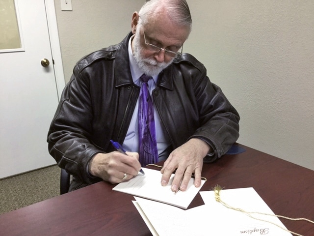 Pastor Ted Williams signs baptismal certificates for three men at Crowley County Correctional Facility in Olney Springs, Colorado, United States. [Photo: Rajmund Dabrowski]