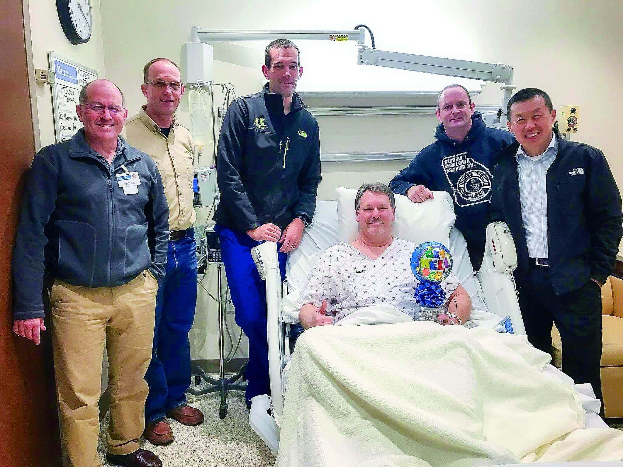 The five cyclists visit the man they saved, now safe in the hospital. Nurse James DeLong is the third behind the patient.