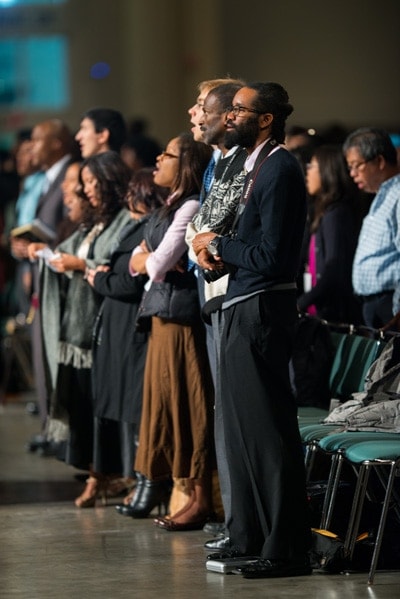 <strong>STANDING FOR PRAYER: </strong>GYC Delegates stand before prayer at conclusion of meeting. [Adam Jackson/GYC}