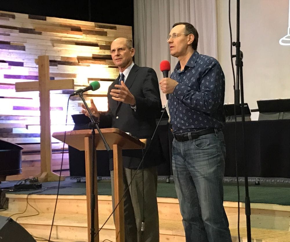 Pastor Ted Wilson, General Conference president, at left, speaking at an orientation meeting on the Bucha campus as Euro-Asia Division president Michael Kaminskiy interprets into Russian. (Andrew McChesney / Adventist Mission)