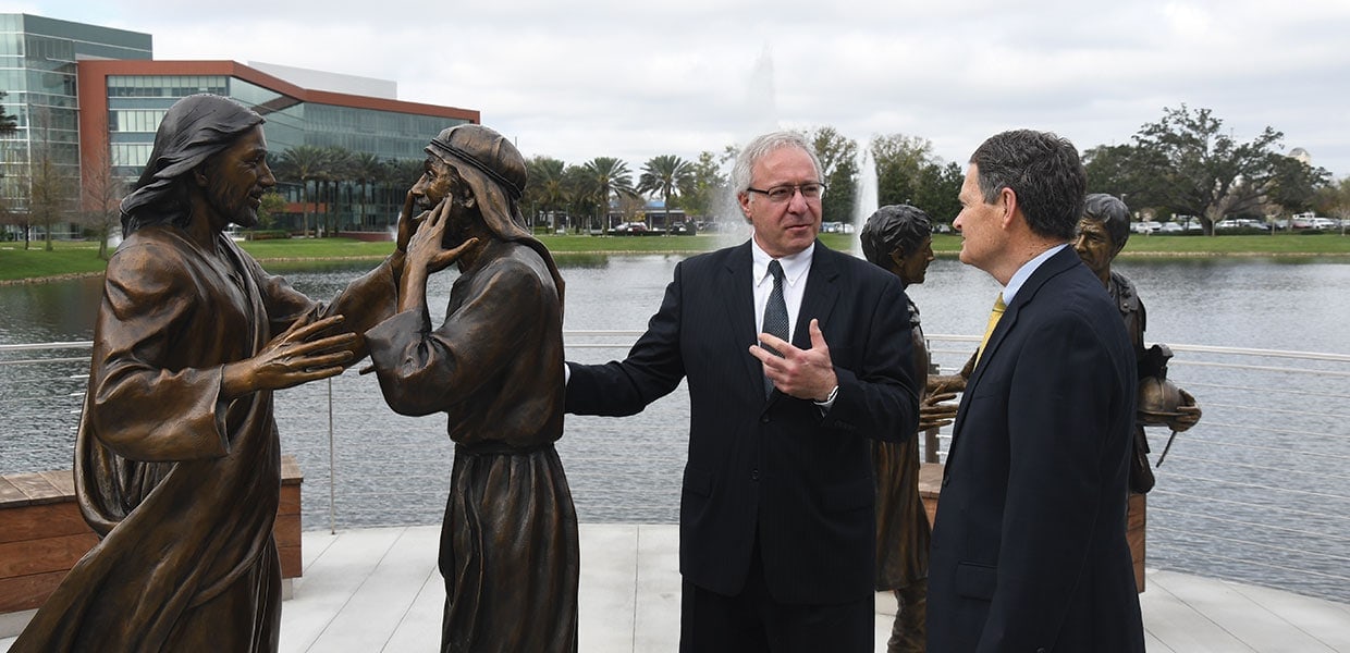 Sculptor Victor Issa (left) talks with Ted Hamilton, AdventHealth's chief mission integration officer, about The Master Healer statue on the campus of AdventHealth’s corporate office in Altamonte Springs, Florida, United States. [Photo: Southern Tidings]
