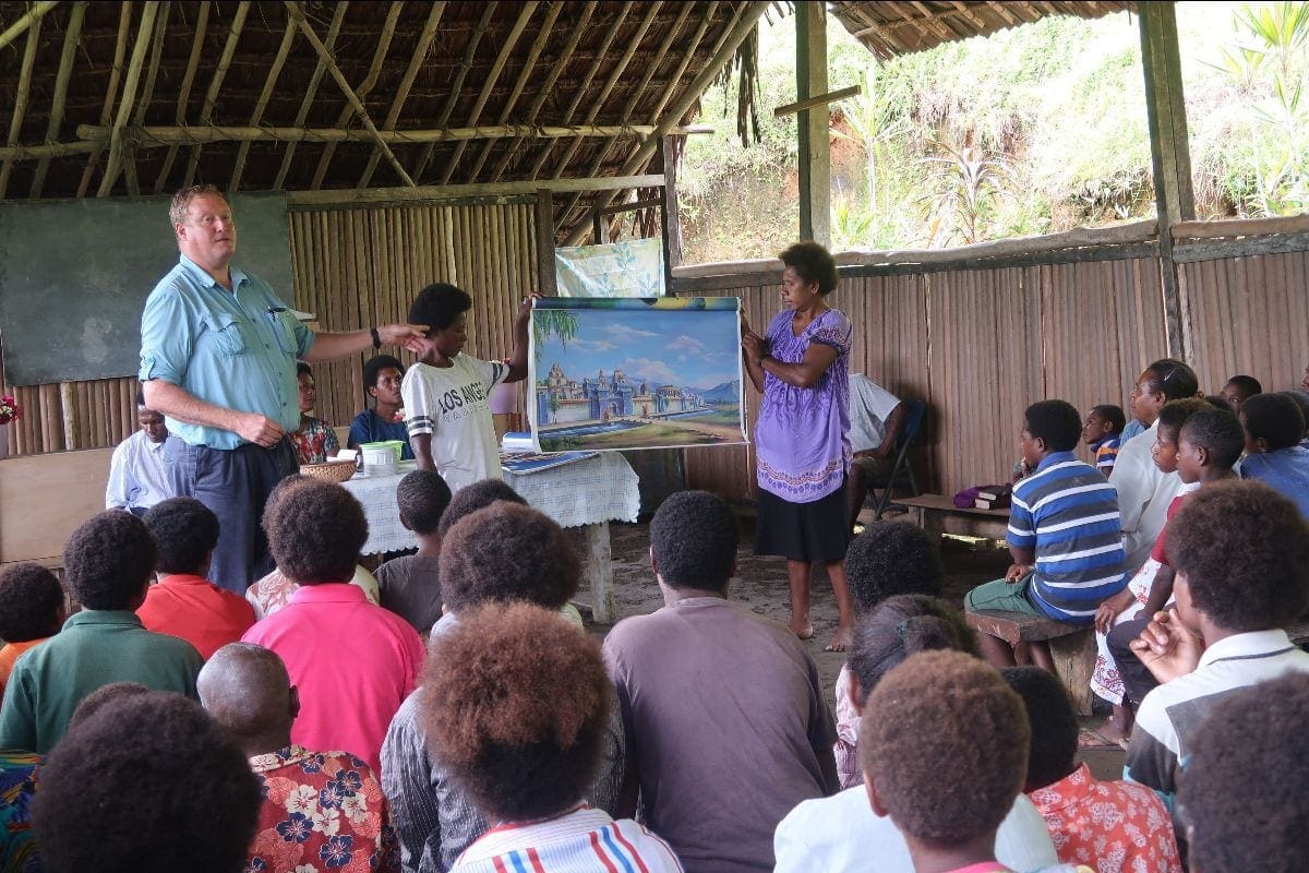 Orion Lawrence shares the mission story in the May River Station Church in the East Sepik province of Papua New Guinea. Pictures rolls are proving to be an effective mission and evangelistic tool for both adults and children in the area. [Photo: Adventist Laymen’s Services and Industries]