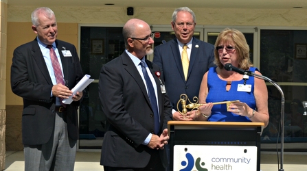 Margaret Brennan, president and CEO of Community Health Centers, receives a ceremonial key, representing the transition in ownership, from Florida Hospital Apopka Administrator Tim Cook. [Photo: Florida Hospital News]