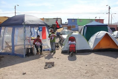 Residents whose homes were damaged in last week’s powerful earthquake take shelter in tents at a makeshift camp outside Alto Hospicio, Chile. [photo courtesy ADRA Chile]