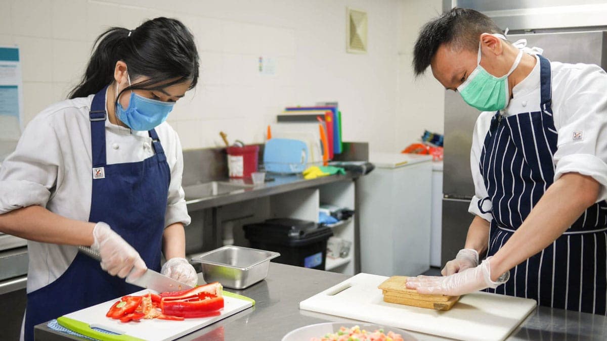 Chefs Feny Belinda and Henry Pun prepare food to be included in Life.Box meals donated to frontline health-care workers in Melbourne, Australia, during the 2020 pandemic. [Photo: Adventist Record]