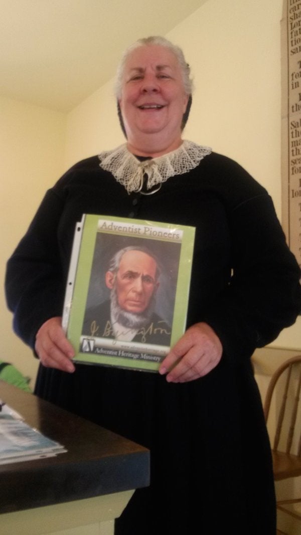 Sylvia Byington Nosworthy holding a portrait of her great-great-grandfather John Byington at the Historic Adventist Village in Battle Creek, Michigan. Photo: Krystal Eskildsen