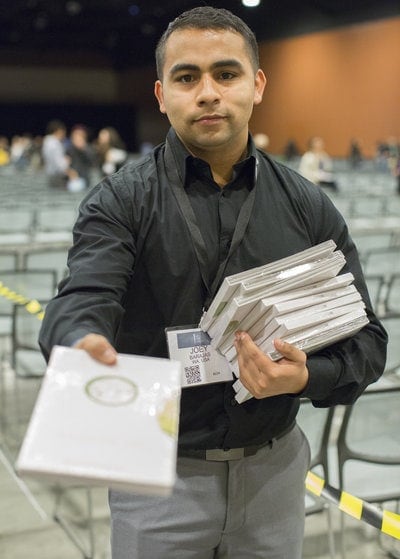 GYC delegate Joey Barajas, of Washington state, passing out sets of Bible study lessons called "Ttruth Link" by Ty Gibson of Light Bearers, an independent Adventist ministry, at the convention. Photo: Seth Shaffer