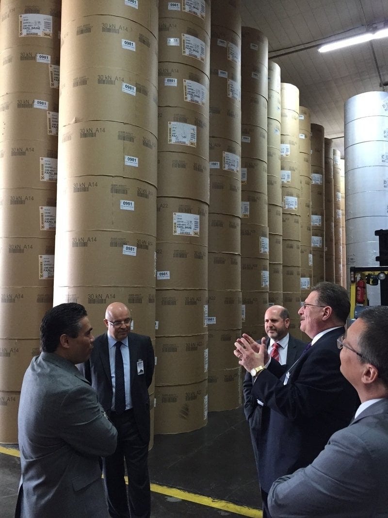 Bill Knott, center right, discussing printing issues with his Brazilian hosts near columns of paper drums at the Adventist publishing house in Brazil. Gerald Klingbeil is at the far right. (Claude Richli / AR)